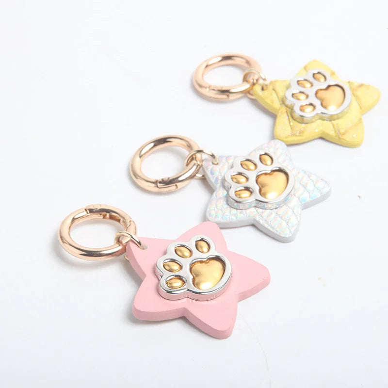 Close-up of star pet tags showing scale texture and gold paw print detail