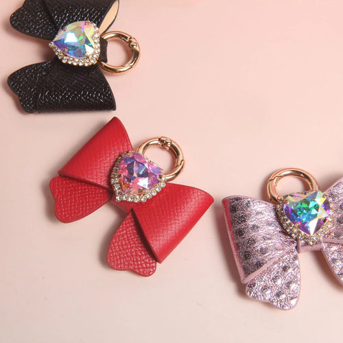 Heart rhinestone butterfly bow charms in black red and pink colors on pink background