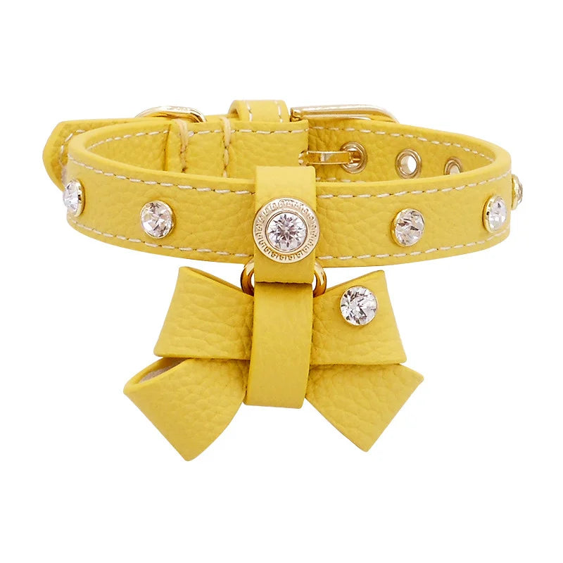Crystal-studded bow pendant on green leather cat collar close-up