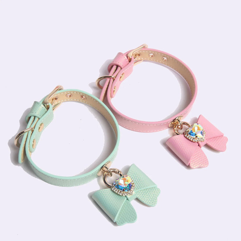 Close-up of mint green leather collar with butterfly bow and heart-shaped iridescent rhinestone