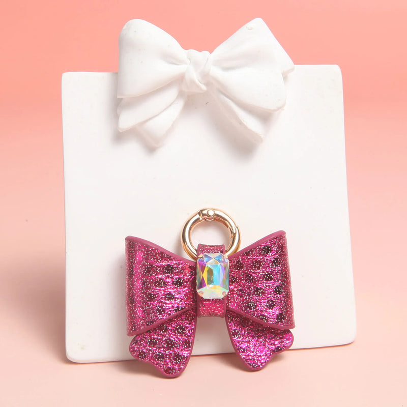 Side view of butterfly bow charms showing leather texture and gold hardware