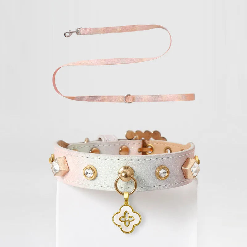 A luxury iridescent pastel pink and silver glitter pet collar set with clear rhinestones, gold geometric studs, and a white quatrefoil charm, accompanied by a matching thin leash on a white studio background.