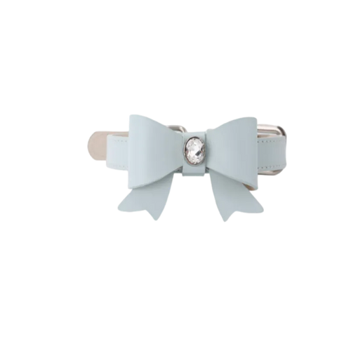 A stylish light blue leather dog collar featuring a large matching bow adorned with a sparkling oval crystal center piece against a black background.