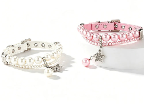 An elegant pair of luxury dog collars in soft pink and white leather, each featuring two strands of faux pearls and a sparkling rhinestone-encrusted star charm, displayed on a clean white background.