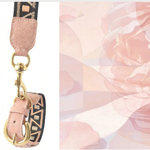 Close-up of a dusty pink pebble-grain leather bag strap featuring a polished gold swivel hook and a woven fabric band with a black and tan geometric pattern, set against a soft pink floral watercolor background.