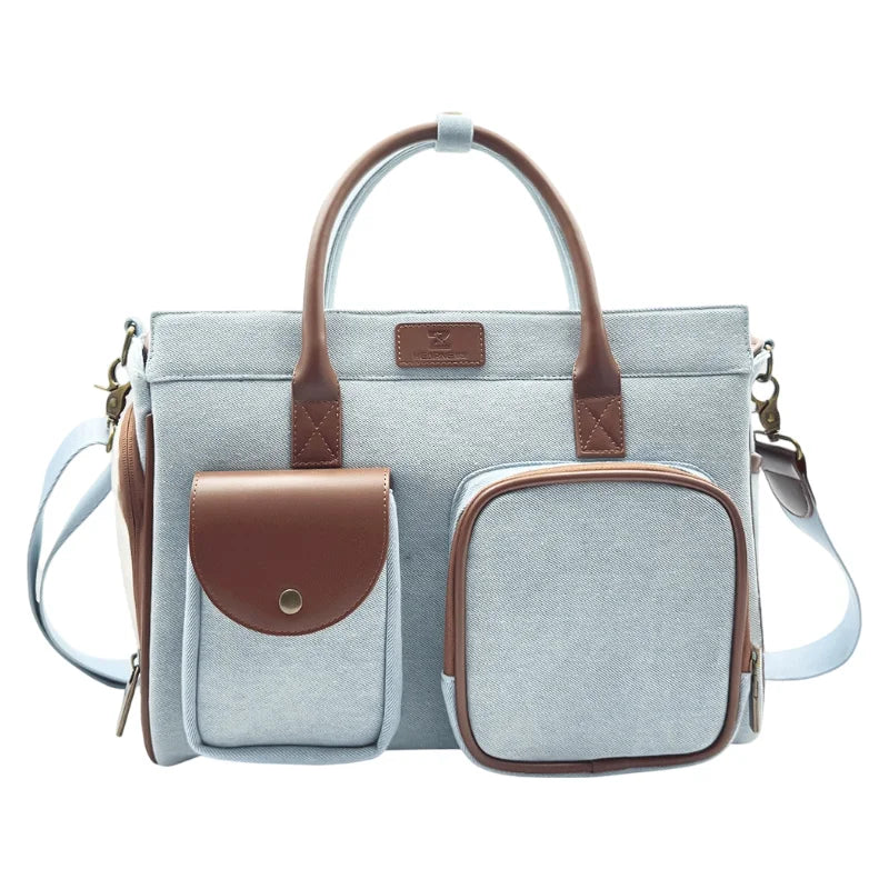 Light blue-gray pet carrier bag with brown leather details, front pockets and antique brass hardware
