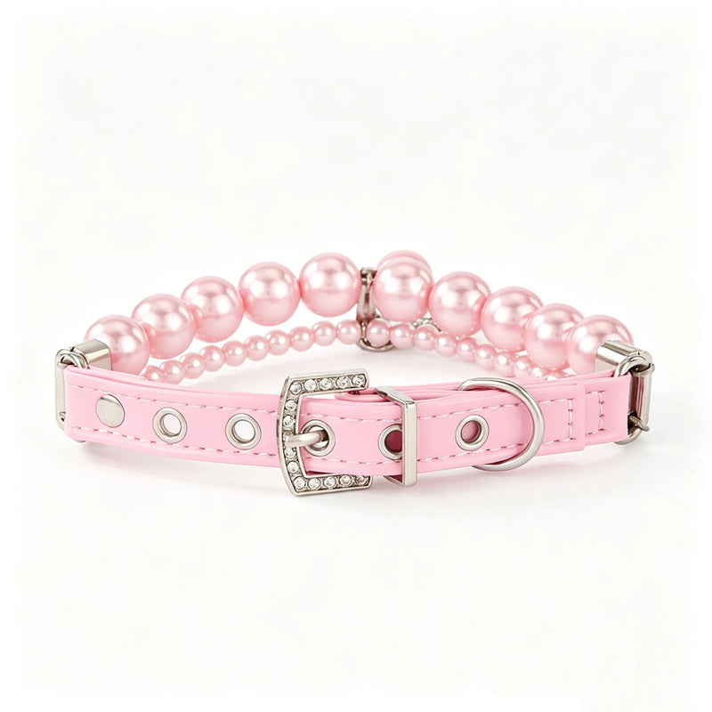 A luxury pink faux leather dog collar adorned with double rows of pink pearls and a silver buckle encrusted with shimmering rhinestones against a clean white backdrop.