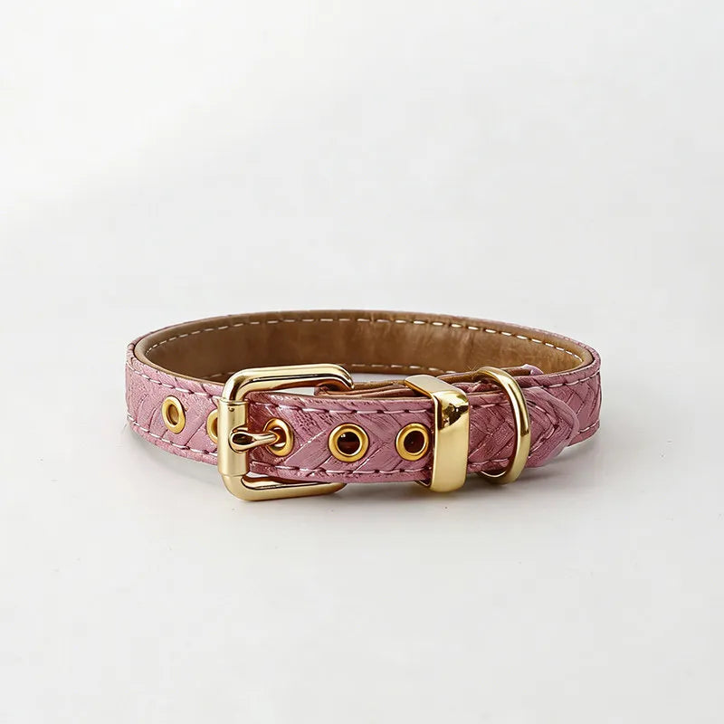 A luxurious pink textured leather pet collar with a metallic finish, featuring polished gold-tone hardware, eyelets, and a buckle, set against a clean white background.