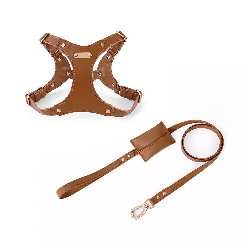 A sophisticated tan eco-leather dog harness and matching leash set with gold-tone hardware and an integrated poop bag dispenser pouch on a white background.