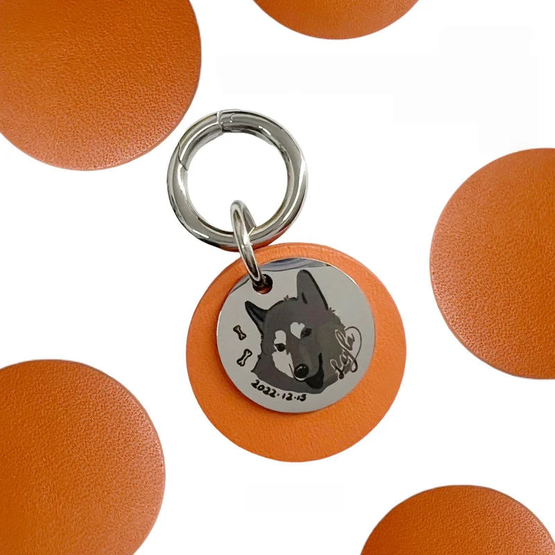 Round engraved pet ID tag with dog face and paw print icons on orange background