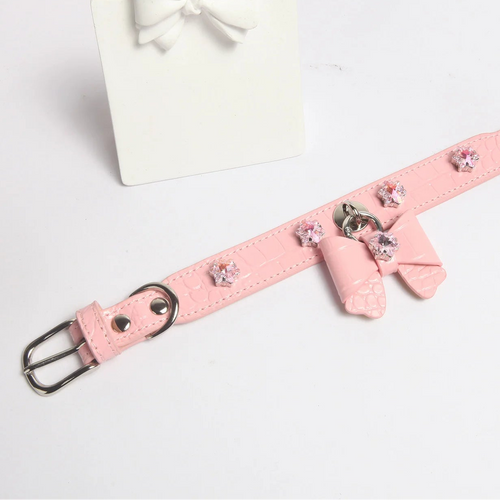 Dog wearing pink snowflake crystal bow collar showing silver hardware and crocodile texture
