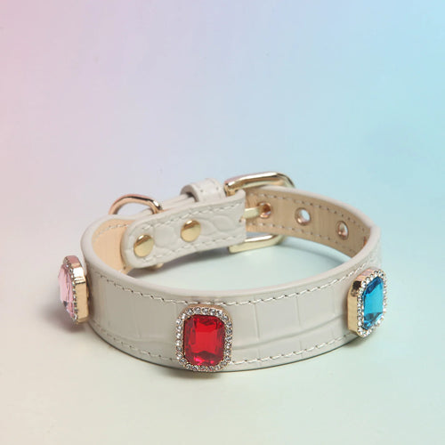 Close-up of white crocodile-embossed leather collar with red, pink and blue square crystals in gold frames